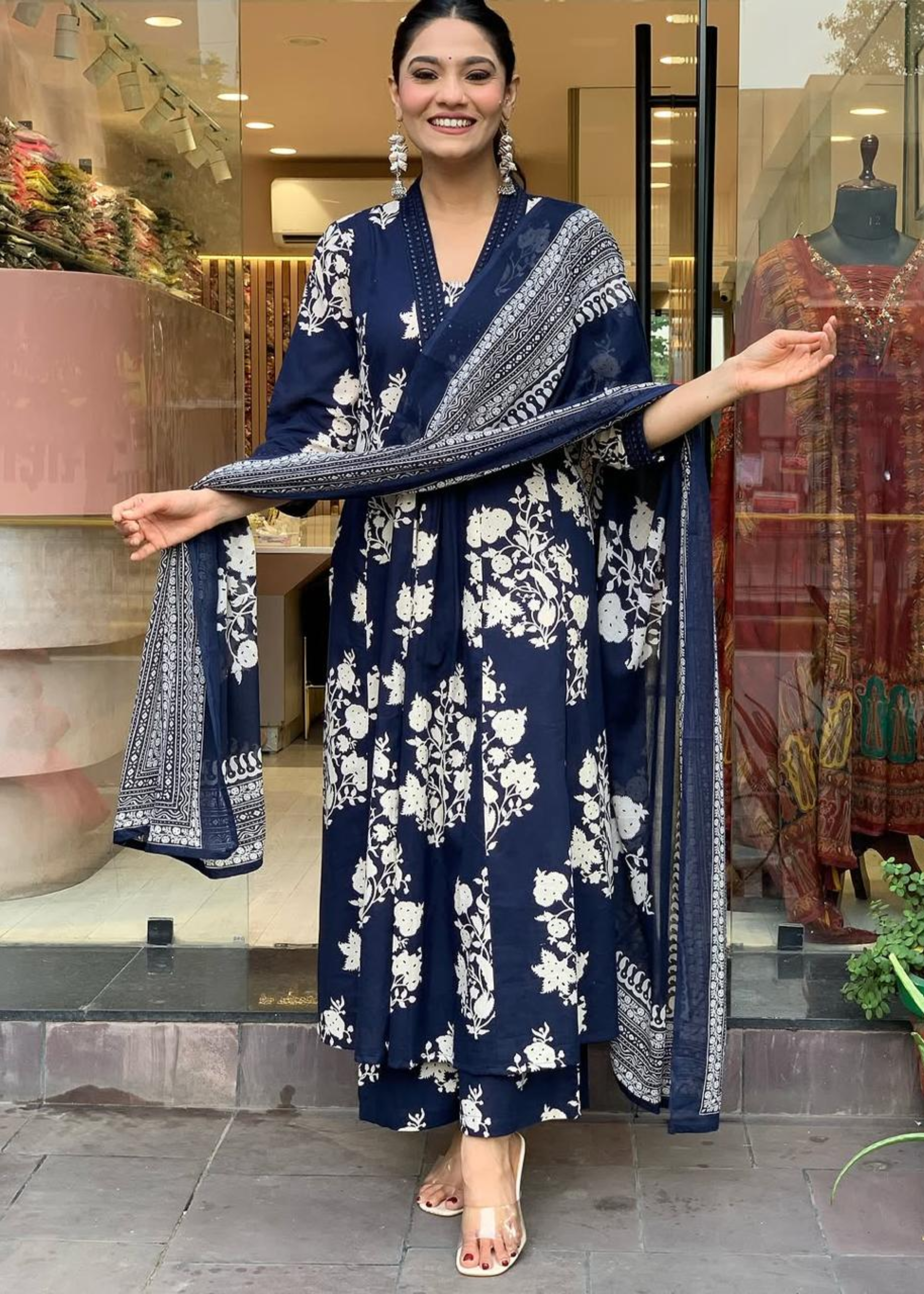 Sophisticated navy and white floral ensemble featuring a pleated V-neck A-line kurta, stylish palazzos, and a matching dupatta.