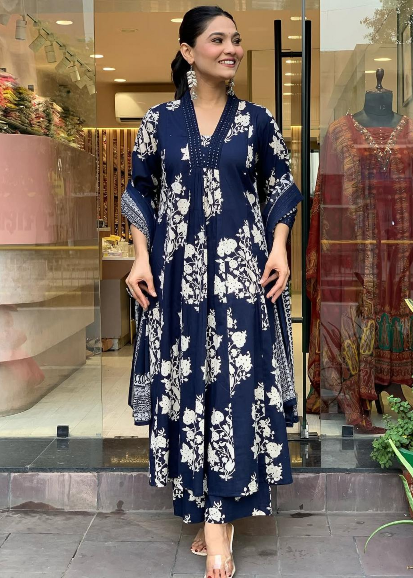Chic and breezy floral printed A-line kurta with a V-neck, pleated detailing, and a matching palazzo-dupatta set in navy and white.