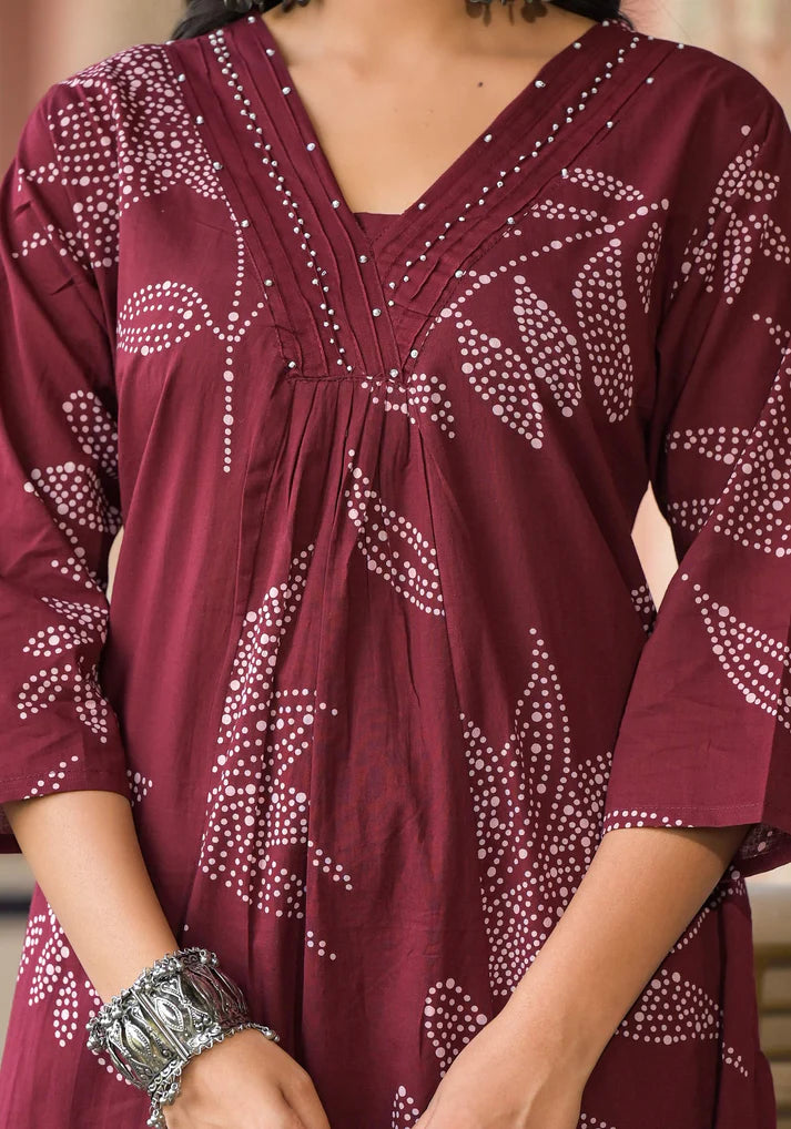 Chic and stylish Mehroon floral printed A-line kurta set adorned with delicate bead embellishments for a festive touch.