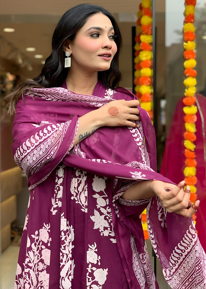 Feminine and breezy magenta floral kurta set with a pleated V-neck, flowy A-line silhouette, and complementing palazzos and dupatta.
